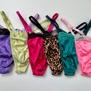 May include: A set of three ceramic mugs with a speckled, matte finish. The mugs are in shades of cream, light gray, and dark gray. Each mug has a simple, modern design and a rounded handle.