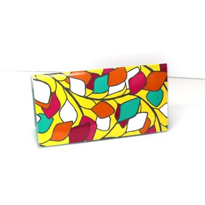 May include: A yellow wallet with a colorful abstract pattern of red, green, white, and orange shapes.