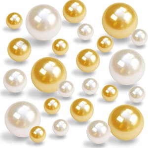 May include: An assortment of lustrous pearls in various sizes and shades of white and gold. The pearls are scattered across a white background, creating a visually appealing display. The image showcases the natural beauty and elegance of these classic gemstones.