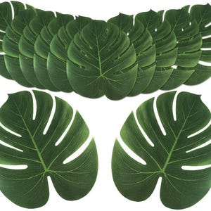 May include: A collection of artificial Monstera leaves in various sizes. The leaves are a vibrant green with white veins, mimicking the natural appearance of the tropical plant. The leaves are arranged in a layered pattern.