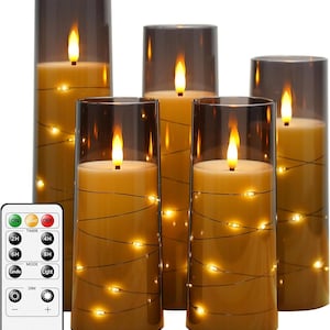 May include: Set of four brown glass candle holders with flickering LED candles and a remote control. The remote has buttons for on, off, timer, mode, and dim.