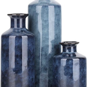 May include: Three blue ceramic vases of varying sizes. The vases have a mottled blue glaze and a rounded shape.