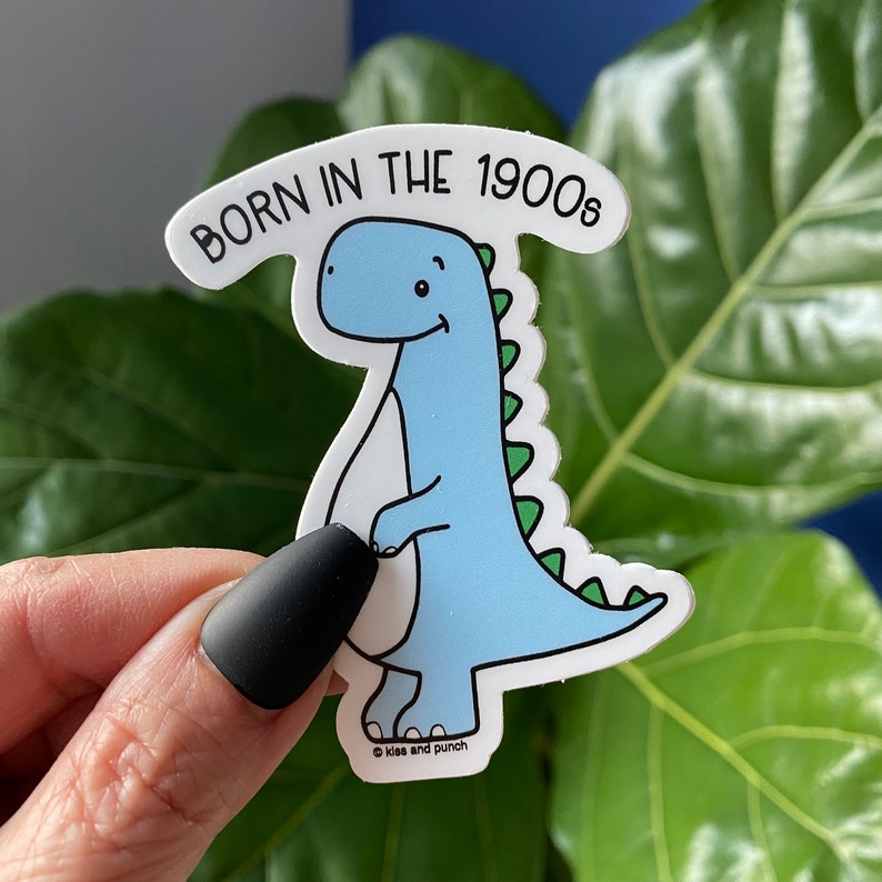 Hand holding 3 inch cute blue dinosaur with text that reads "Born in the 1900s"