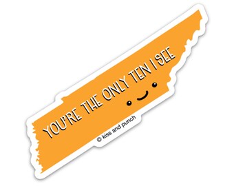 Könnte beinhalten: Orangener Aufkleber in Form des Bundesstaates Tennessee mit dem Text "You're the only ten I see" und einem Smiley. Der Aufkleber trägt das Copyright-Symbol und den Text "Kiss and punch".