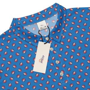 May include: A blue polo shirt with a repeating pattern of red and white floral designs. The shirt has a collared neckline, a button-down placket, and a tag with the text "greatday designs".
