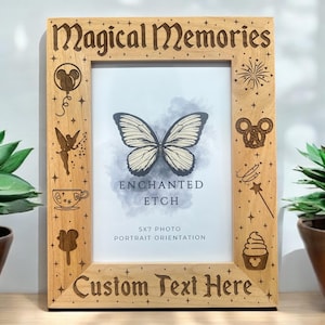 May include: Wooden photo frame with the words "Magical Memories" and "Custom Text Here" engraved. The frame features etched designs of a butterfly, fairy, and other whimsical elements. Holds a 5x7 photo.