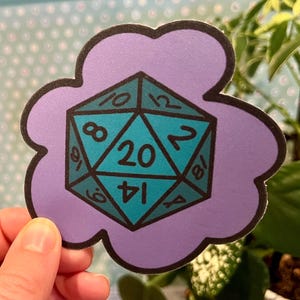 May include: A purple cloud-shaped sticker with a teal 20-sided die in the center. The die has black numbers and a black outline.
