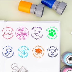 Puede incluir: Un conjunto de ocho sellos redondos para maestros de colores vivos con diferentes mensajes e ilustraciones. Los sellos incluyen mensajes como "Bien hecho", "Buen trabajo", "Eres súper", "Lo vales" y "El mejor de la clase".