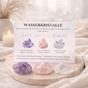 Könnte beinhalten: Eine Karte mit dem deutschen Text "WASSERKRISTALLE" und Illustrationen von Kristallen: Amethyst, Rosenquarz und Bergkristall. Darunter drei rohe Kristalle: lila, rosa und klar. Die Karte beschreibt die Eigenschaften der Kristalle.