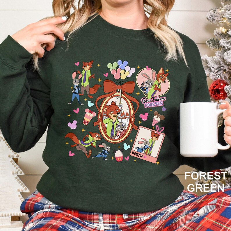 Puede incluir: Sudadera verde bosque con personajes de dibujos animados, incluyendo un zorro y un conejo, con las palabras "Best Friends Forever" y "Bestie". El dise&ntilde;o incluye corazones, conos de helado y un lazo.