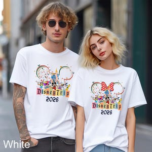 May include: White t-shirts with a colorful Disney Trip 2026 graphic. The design includes Mickey Mouse, Minnie Mouse, and other Disney characters. The shirts have short sleeves and a crew neck.