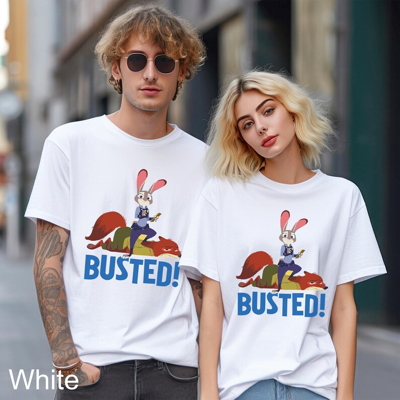 May include: White t-shirts featuring a cartoon image of a rabbit character riding a fox, with the word "BUSTED!" in blue. The shirts are short-sleeved and have a crew neck.