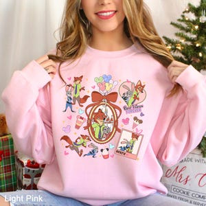 Puede incluir: Sudadera rosa claro con un dise&ntilde;o de dibujos animados que presenta un zorro y un conejo. El dise&ntilde;o incluye el texto "Best Friends Forever" y "Bestie", junto con corazones, globos y helados.