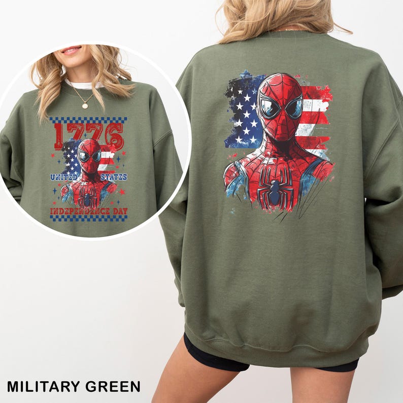 May include: An olive green crewneck sweatshirt featuring a graphic of Spider-Man against a stylised American flag. The back displays a large print, while the front shows a smaller version with the text 1776 UNITED STATES INDEPENDENCE DAY.
