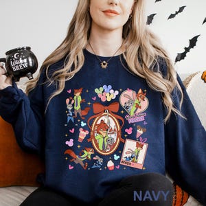 Puede incluir: Sudadera azul marino con un gr&aacute;fico colorido de personajes de dibujos animados, incluyendo un zorro y un conejo, con las palabras "Best Friends Forever" y "Bestie". El dise&ntilde;o incluye corazones, globos y conos de helado.