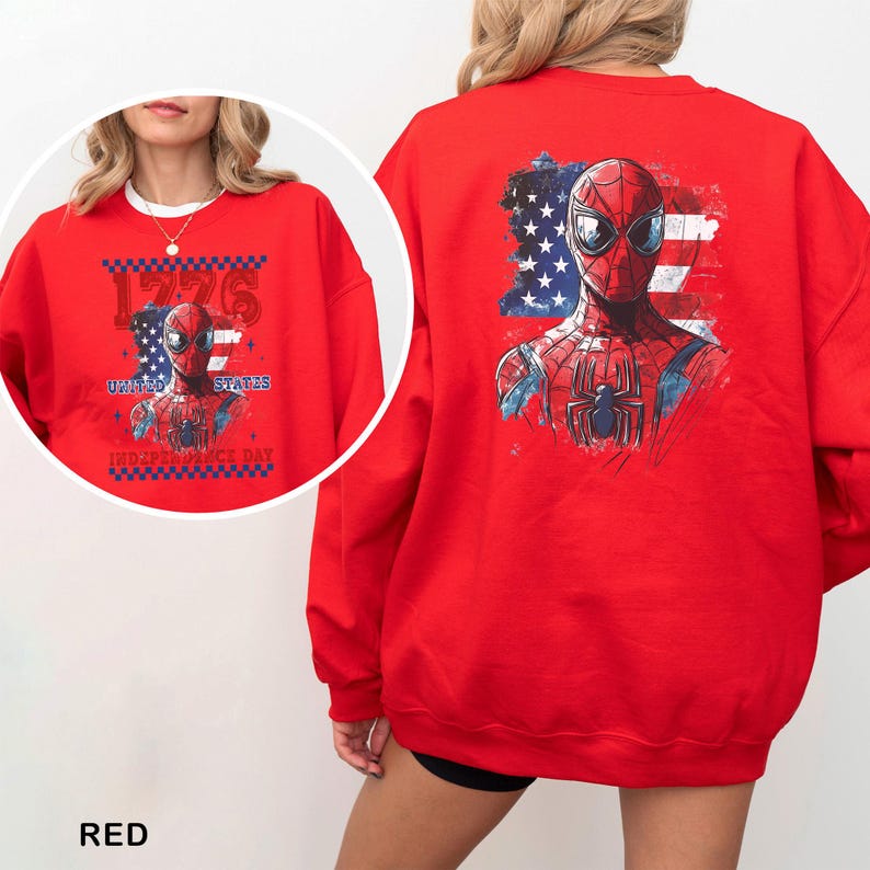 May include: A bright red crewneck sweatshirt featuring a graphic of the superhero Spider-Man layered over a distressed American flag. The design includes the text 1776, UNITED STATES, and INDEPENDENCE DAY in a bold, blocky font with a checkered border.