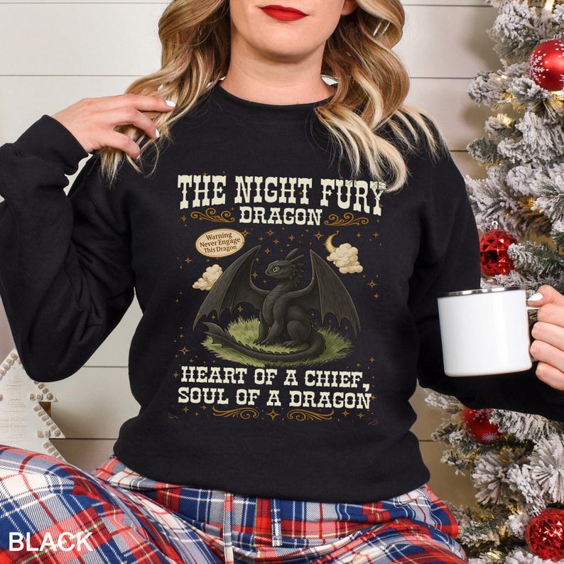 Puede incluir: Sudadera negra con un dise&ntilde;o de drag&oacute;n Night Fury. El gr&aacute;fico incluye el texto "THE NIGHT FURY DRAGON" y "HEART OF A CHIEF, SOUL OF A DRAGON". Una etiqueta de advertencia dice "Warning Never Engage This Dragon".