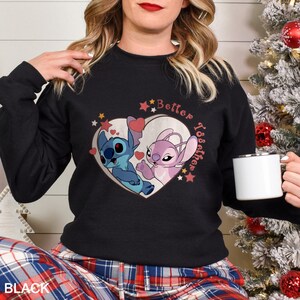 May include: Black sweatshirt with a pink and blue heart design featuring Stitch and Angel from the Disney movie Lilo & Stitch. The text "Better Together" is printed above the heart.