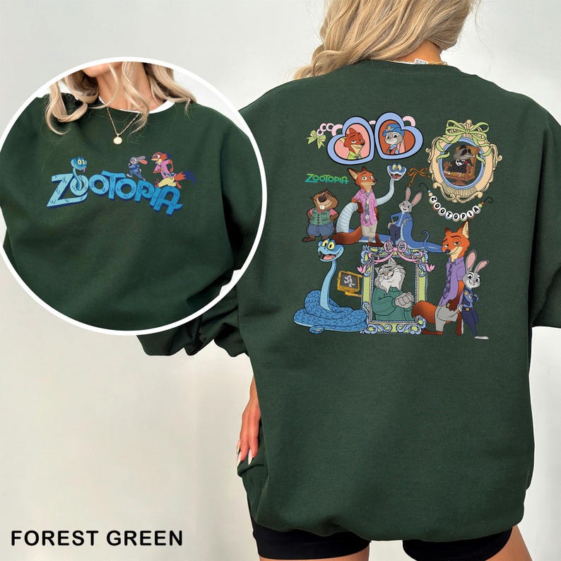 K&ouml;nnte beinhalten: Forstgr&uuml;nes Sweatshirt mit dem Wort "Zootopia" in blauer Schrift auf der Vorderseite. Auf der R&uuml;ckseite befindet sich ein farbenfrohes Design mit Zootopia-Charakteren. Das Sweatshirt hat einen Rundhalsausschnitt.