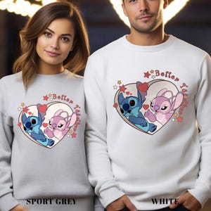 May include: A pair of grey and white sweatshirts with a heart design featuring the characters Stitch and Angel from the Disney movie Lilo & Stitch. The text "Better Together" is written in a pink heart shape.