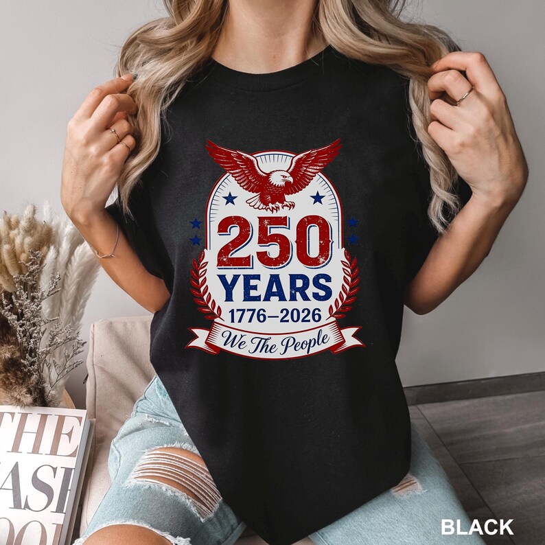 May include: Black t-shirt featuring a patriotic design with a red and white eagle, stars, and the text "250 YEARS 1776-2026 We The People". The design is centered on the front of the shirt.