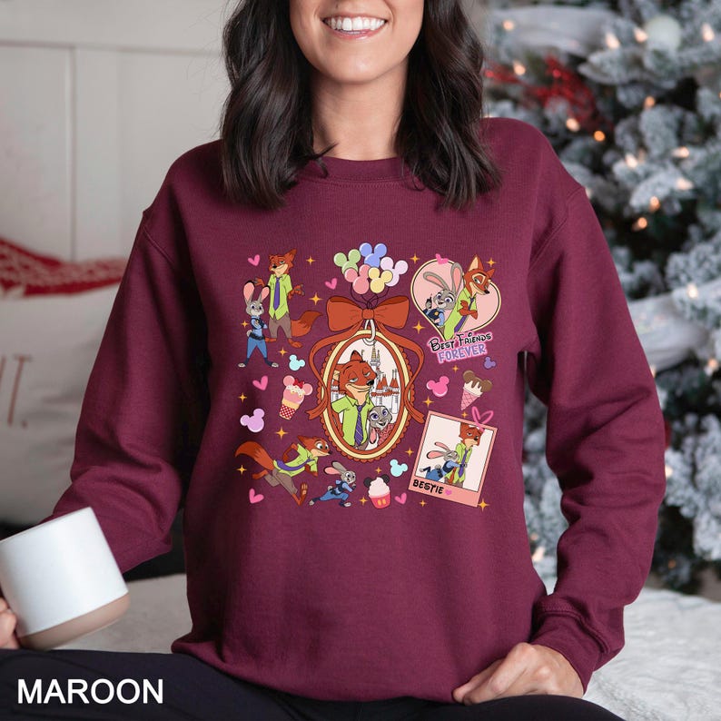 Puede incluir: Sudadera granate con personajes de dibujos animados. El dise&ntilde;o incluye un marco ovalado central con un zorro y un conejo, rodeado de corazones, globos y las palabras "Best Friends Forever" y "Bestie".