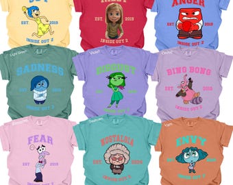 May include: A collection of nine colorful t-shirts featuring characters and text from the movie "Inside Out 2." Each shirt displays a different emotion or character name, such as "Joy," "Riley," and "Anger," along with the movie title and the year 2019 or 2024.