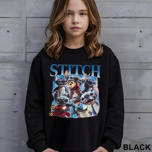 Op de afbeelding: Zwarte sweatshirt met een afbeelding van het personage Stitch uit de film Lilo & Stitch. Het woord "STITCH" is in blauw boven de afbeelding gedrukt. Het woord "BLACK" is rechtsonder in het wit gedrukt.