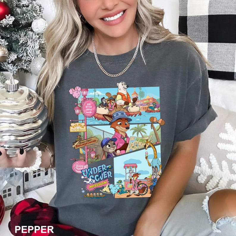 May include: Dark grey t-shirt with a colourful cartoon graphic and the text "Undercover Mission." The graphic shows animal characters in a theme park. The shirt has short sleeves and a relaxed fit.