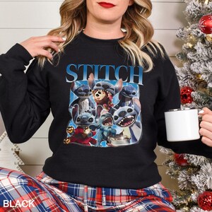 Op de afbeelding: Zwarte crewneck sweatshirt met een afbeelding van Stitch uit Lilo & Stitch. Het woord "STITCH" staat in het blauw bovenaan gedrukt. De afbeelding toont Stitch in verschillende poses. De linker benedenhoek van de sweatshirt heeft het woord "BLACK".