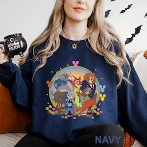 May include: Navy blue sweatshirt featuring a colorful cartoon graphic of animal characters. The design includes a rainbow, flowers, and Mickey Mouse-shaped balloons. The word "NAVY" is printed at the bottom.