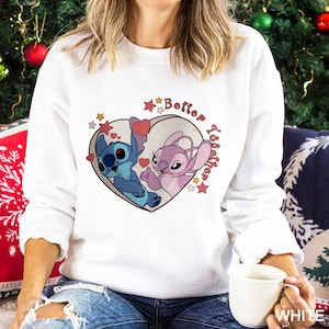 May include: White sweatshirt with a pink heart design featuring Stitch and Angel from Lilo & Stitch. The heart has the text "Better Together" inside.