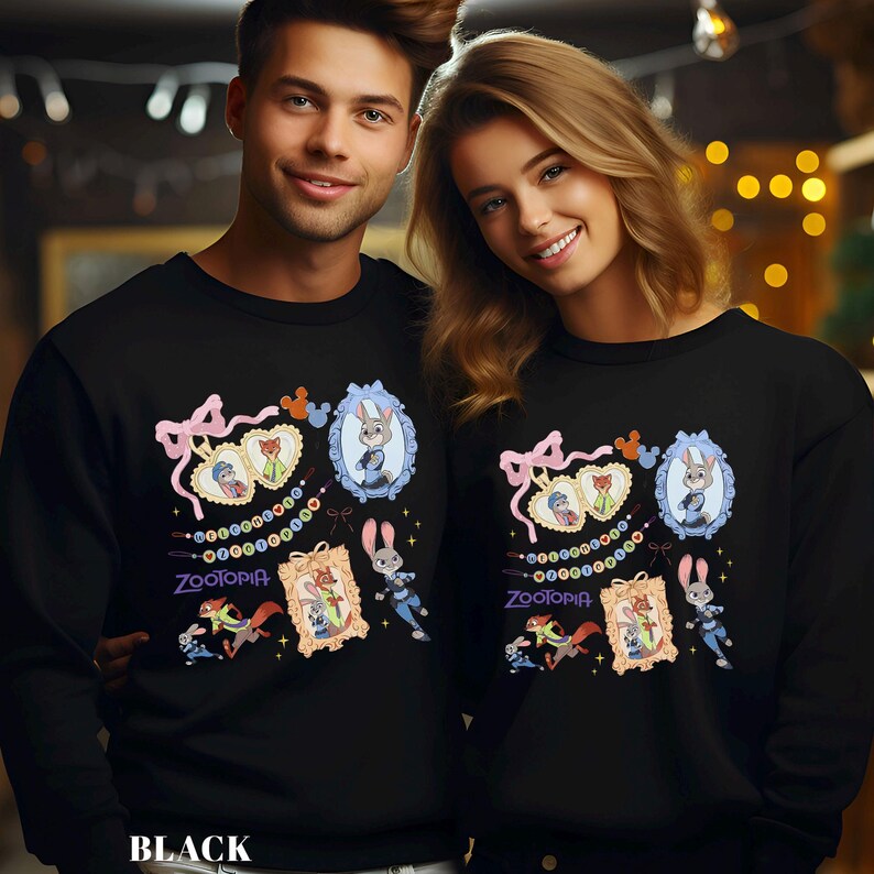 May include: Black sweatshirts featuring a colorful Zootopia design. The design includes framed character portraits, a pink bow, and the word "Zootopia". The sweatshirts are worn by two people.
