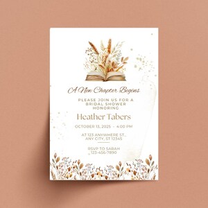 Op de afbeelding: Een witte uitnodigingskaart met een aquarel-illustratie van een boek versierd met gedroogde bloemen en gouden glitter. De tekst luidt "A New Chapter Begins" en bevat details voor een bruidsdouche ter ere van Heather Tabers op 13 oktober 2025 om 16:00 uur.