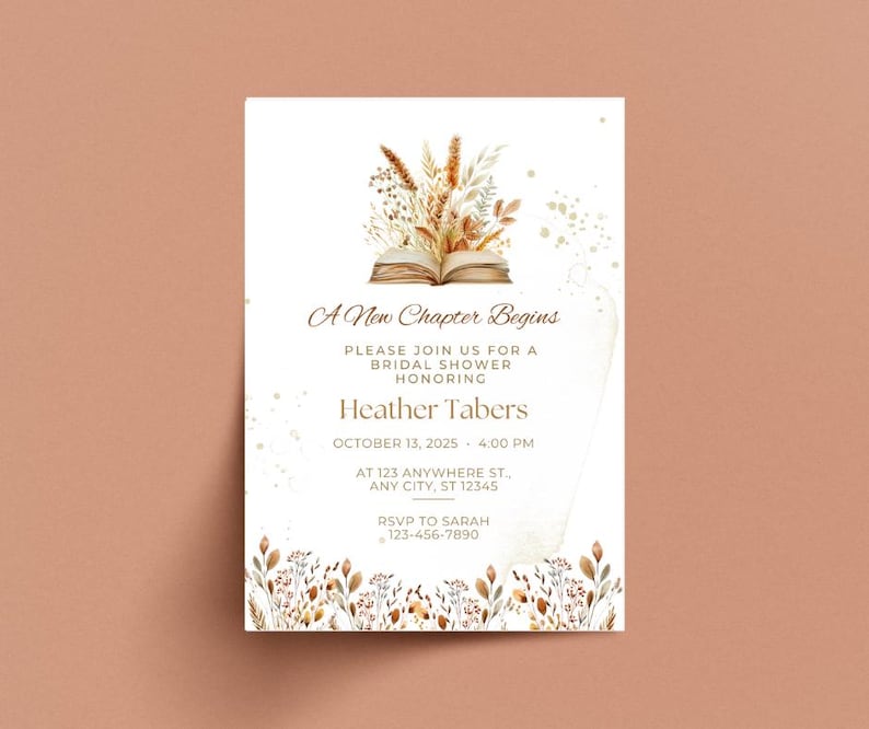 Op de afbeelding: Een witte uitnodigingskaart met een aquarel-illustratie van een boek versierd met gedroogde bloemen en gouden glitter. De tekst luidt "A New Chapter Begins" en bevat details voor een bruidsdouche ter ere van Heather Tabers op 13 oktober 2025 om 16:00 uur.