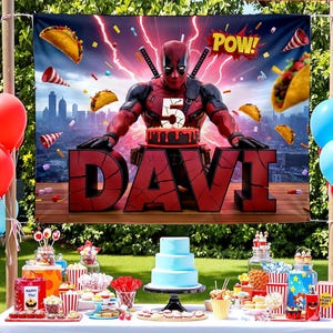May include: A party banner featuring Deadpool with the name "DAVI" and the number "5" on a cake. The banner has a cityscape background with tacos and the word "POW!". Red, blue, and white balloons and a table with treats complete the scene.