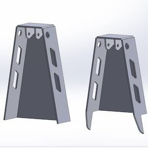 May include: Two gray metal brackets with a trapezoidal shape. Each bracket has rectangular and circular cutouts along the sides and top. The brackets are designed with a flat top and a wider base, with one having a leg extension.