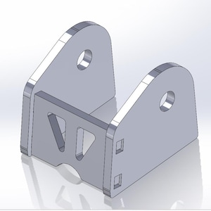 Op de afbeelding: Een grijze metalen beugel met een U-vormig ontwerp. De beugel heeft twee afgeronde bovenste secties met cirkelvormige gaten en een verbindende middensectie met driehoekige uitsparingen. Twee rechthoekige uitsparingen zijn aan de onderkant zichtbaar.