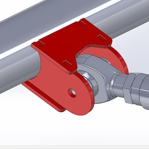 May include: A red bracket with a curved design is attached to a silver metal tube. The bracket has a hole and is connected to a grey metal component with a threaded end. The image is a close-up.