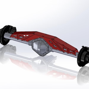 May include: A red and silver vehicle axle assembly. The axle has a red, angular protective plate and black brake components at each end. The design is rendered with a reflective surface, highlighting the mechanical details.