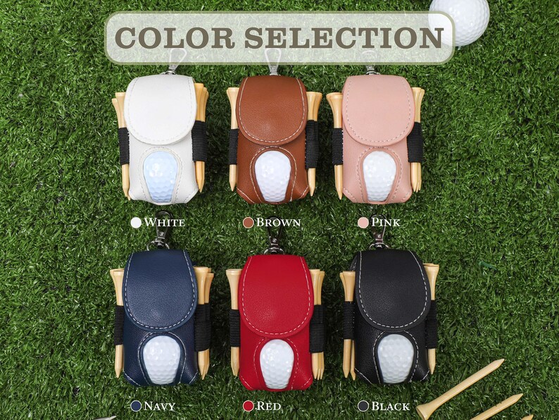 K&ouml;nnte beinhalten: Auswahl an Golfballhaltern in Wei&szlig;, Braun, Rosa, Marineblau, Rot und Schwarz. Jeder Halter hat einen Golfball und Holztees. Der Text "COLOR SELECTION" steht oben, mit Farbbezeichnungen darunter.