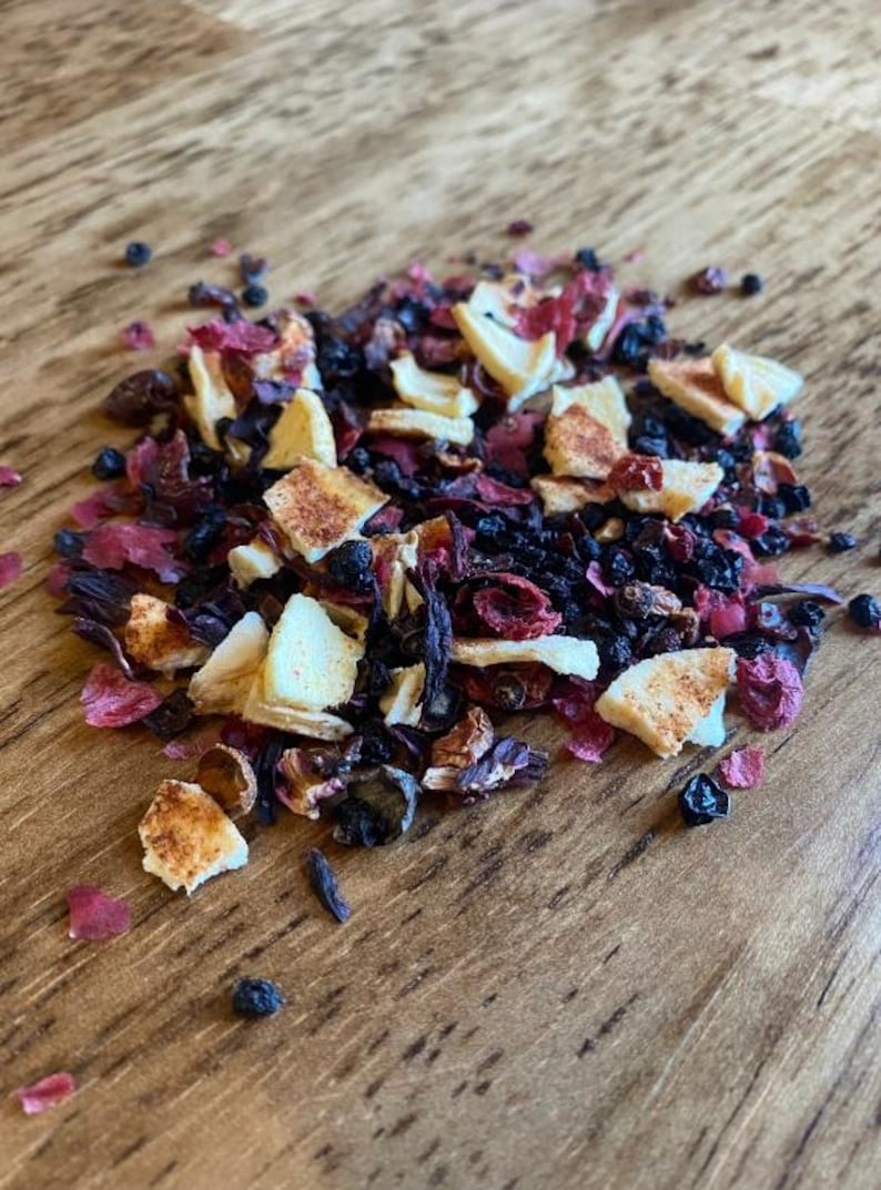 K&ouml;nnte beinhalten: Nahaufnahme einer Mischung aus getrockneten Fr&uuml;chten, Kr&auml;utern und Gew&uuml;rzen f&uuml;r Tee. Die Mischung enth&auml;lt getrocknete &Auml;pfel, Beeren und schwarzen Tee.