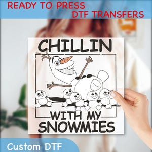 May include: A white iron-on transfer design featuring a cartoon image of Olaf from Frozen, with the text "Chillin' with my snowmies".