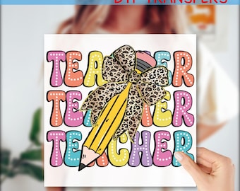 May include: A colorful DTF transfer design with the word "TEACHER" in bubble letters. A yellow pencil and a leopard print bow are in the center. The words "READY TO PRESS DTF TRANSFERS" and "Custom DTF" are also present.