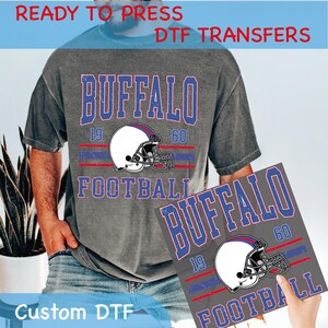 May include: A gray t-shirt and a gray square featuring a football design. The design includes the word "BUFFALO", the numbers "19" and "60", a football helmet, and the word "FOOTBALL". The text "READY TO PRESS DTF TRANSFERS" and "Custom DTF" are also visible.