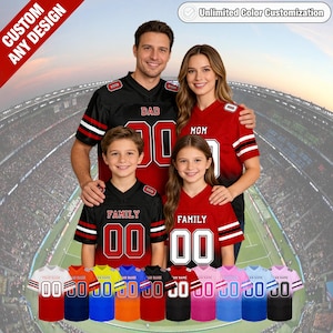 May include: Customisable family football jerseys in black and red, with white numbers and text. The image shows a family wearing the jerseys, with a variety of colour options displayed below. The jerseys are designed for personalisation.