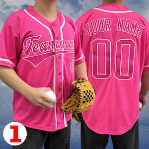 May include: Pink baseball jersey with white piping and a white "Teammates" graphic on the front. The back of the jersey has a white "YOUR NAME" and a white number "00".