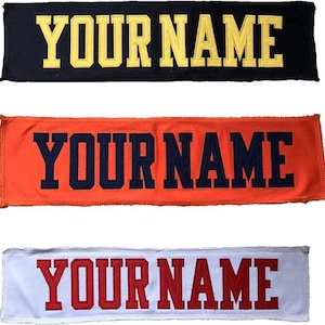 May include: Three embroidered patches with the text "YOUR NAME". The top patch is navy blue with yellow lettering. The middle patch is orange with navy blue lettering. The bottom patch is white with red lettering.