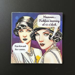 May include: A square sticker featuring a vintage-style illustration of two women wearing cloche hats and beaded necklaces. Speech bubbles contain the text: Hmmmm... Fuckface incoming at 12 o'clock. and Fuckwad for sure. The background is purple.