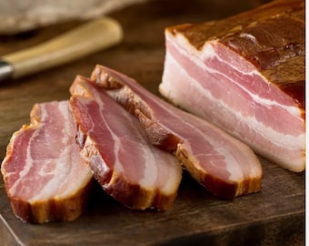 May include: Close-up of four slices of smoked bacon on a wooden cutting board. The bacon is thick-cut and has a rich, brown color.